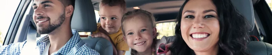 Uśmiechnięta rodzina w wypożyczonym samochodzie w Kaizen Rent